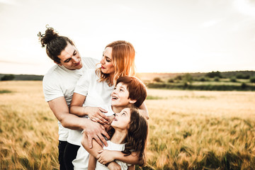 Portrait of a happy young family smiling in the countryside. Concept of family fun in nature.