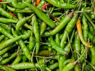 green and orange chili or peppers for sale in the Vegetable market.