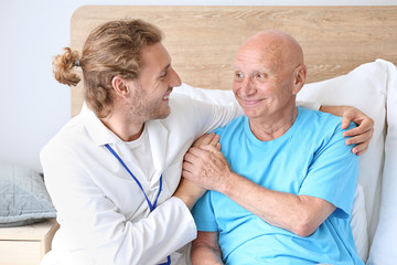 Doctor with elderly man in nursing home
