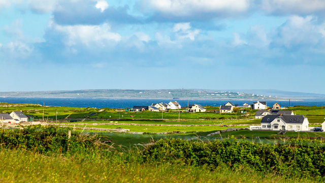 Beautiful meadow, farms and the sea in the background near the village of Doolin, Wild Atlantic Way, beautiful sunny spring day in County Clare in Ireland