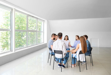 Young people holding hands together at group therapy session