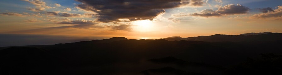 Beautiful sunset over the mountain with clouds. Horizontally.