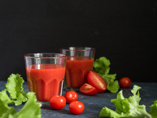 Healthy food. Traditional Spanish cold gazpacho soup with ripe tomatoes or fresh tomato juice in glasses on a dark background