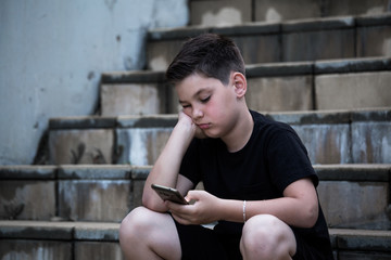 Obraz premium Sad Boy Looking At Mobile Phone With Hand On Head