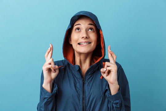 Cheerful young girl wearing raincoat standing