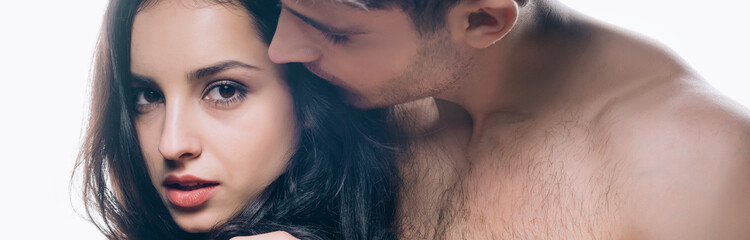 panoramic shot of young man kissing brunette woman isolated on white