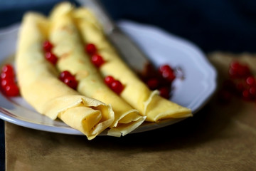 Homemade rolled crepes with chocolate spread and red currants. Selective focus.