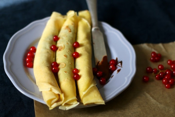 Homemade rolled crepes with chocolate spread and red currants. Selective focus.