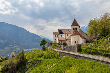 Fototapeta na wymiar Panorama of Church Sankt Peter ob Gratsch, with mountains in the background in the municipality village of Tirol, South Tyrol, Italy. Europe.