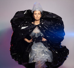 Girl posing in a dress made of plastic film. Fashion portrait.
