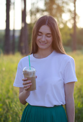 A young girl with dark hair in a white t-shirt walks in the summer.