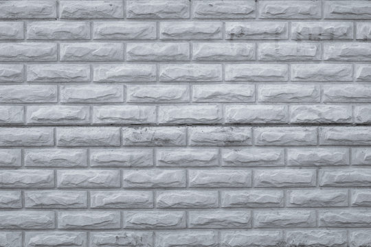 Fototapeta Gray dirty brick wall. Retro pattern with grey bricks wall, grunge background. Rough, vintage concrete texture, urban wall. Old cement brickwork. Copy space. Stone, rock surface.