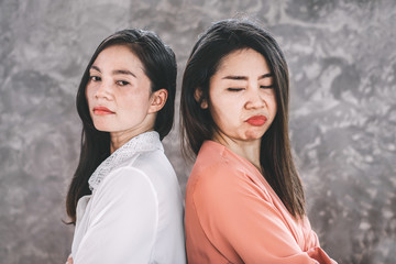 two Asian females enemy workers jealous each other at workplace  