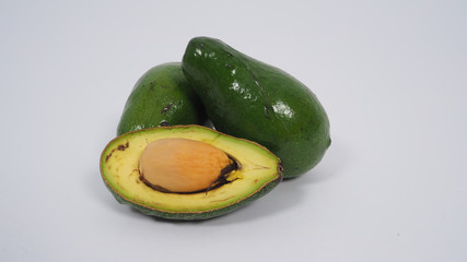 Half Avocado and full avocado on white background.
