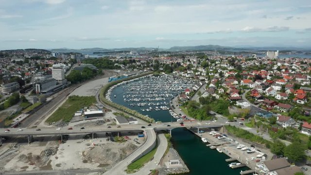 Cinematic Drone Aerial of Stavanger Norway Boats and Yachts Marina With Surrounding Road Bridge Traffic and Residental Houses