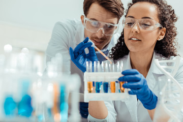 Nice positive woman holding a test tube rack