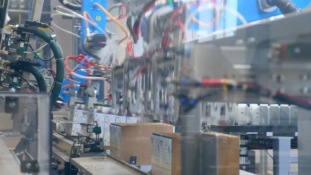 Fast motion of a factory machine packing carton boxes