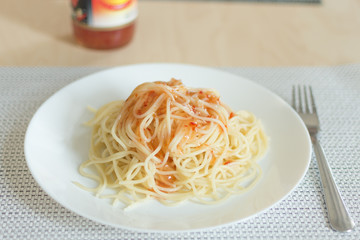 Dish of spaghetti on a plate with sweet savory sauce. Spaghetti serving with sweet chilli sauce.