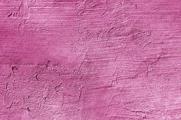 Сraked weathered cement wall texture in pink color.
