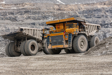 Gigat dump trucks are working in the mine for the production of apatite in the Murmansk region carrying rock.