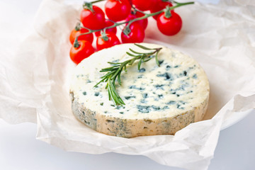 Blue cheese with cherry tomatoes, rosemary on paper