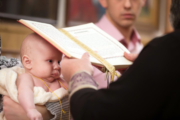 The baptism of a child.The priest performs the ritual of baptism