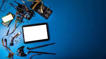 electronic items and digital tablet with blank screen on blue background with copy space