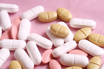 Different pills on the pink background