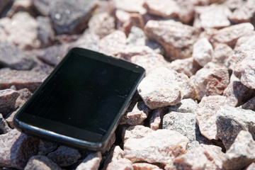 Broken cellphone abandoned and lost among the gravel