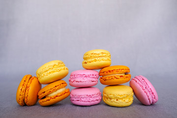 Assorted delicious colorful french macarons on gray background. Different fruity flavours. Sweet food, confectionery. 