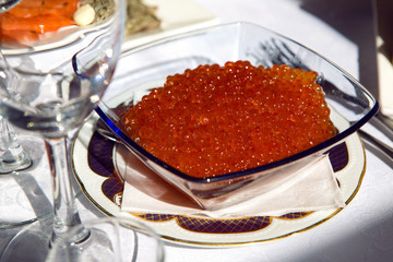 red caviar in a glass plate on the holiday