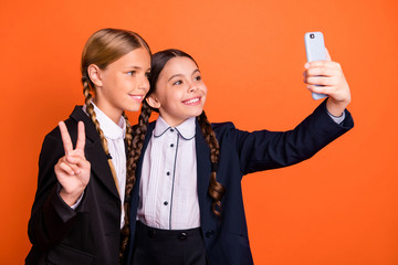 Close up side profile photo beautiful she her little sisters lady hand arm v-sign symbol telephone make take selfies wear formalwear shirt blazer school form bag isolated bright orange background