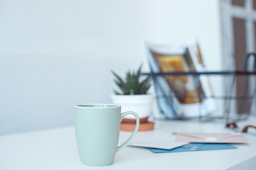 White desk table with copy space, supplies and coffee mug. Front view workspace and copy space