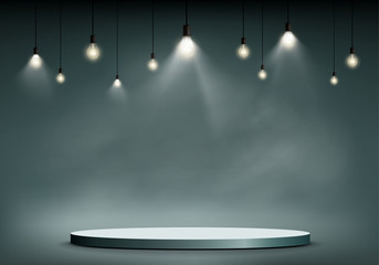 Round stage or podium illuminated by light bulbs.