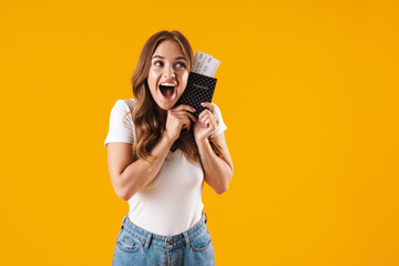 Obraz premium Photo of brunette young woman rejoicing while holding passport and travel tickets