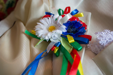 buttonholes on a white suit,wedding costume with artificial flower buttonholes