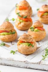 Snack cakes profiteroles with green pea cream and salmon red fish. Exquisite appetizer, tasty lunch, traditional food