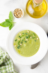 Vegetable green cream soup of peas, spinach, broccoli with pine nuts. Healthy lunch, delicate delicious food