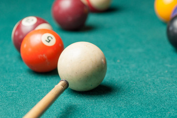 Billiard balls and a stick on a green table. Billiard balls isolated on a green background