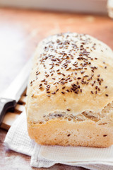 Homemade wheat bread with flax seeds on a kitchen table