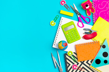 Stationary, back to school,summer time, creativity and education concept.School supplies - dividers, pencils, paper clips,note,stapler and notepad, globe on blue background, flat lay. Mock up.Top view