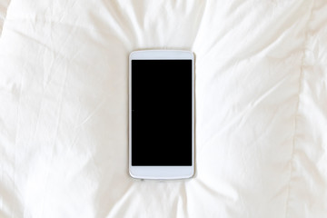 シーツの上に置いたスマートフォン