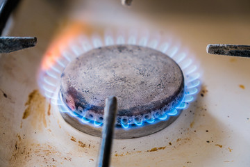 gas burner.blue flame.dirty kitchen stove