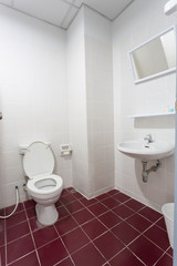 White toilet with red floor textile