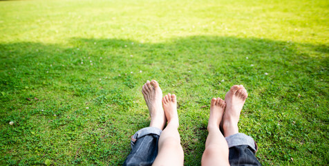芝生で寛ぐ親子の足