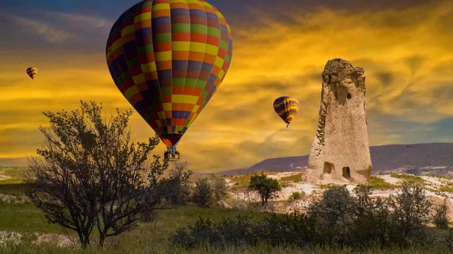 Cinemagraph of fairy chimney in Cappadocia, Turkey, with balloons set against sunset colors and dynamic cloud motion.