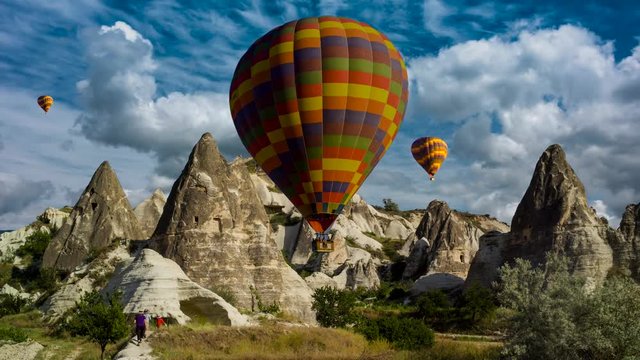 Cinemagraph of hikers in Cappadocia, Turkey, with balloons set against dynamic cloud motion.