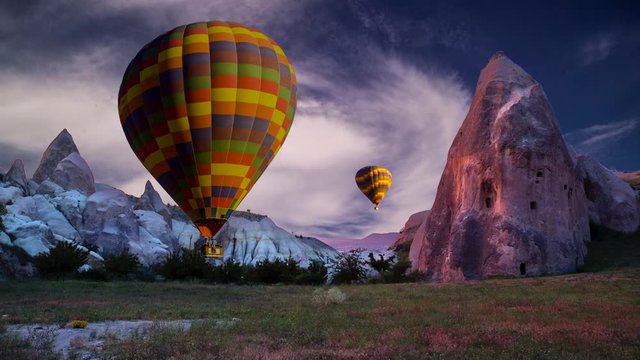 Cinemagraph of fairy chimneys in Cappadocia, Turkey, with balloons set against swirling cloud motion.
