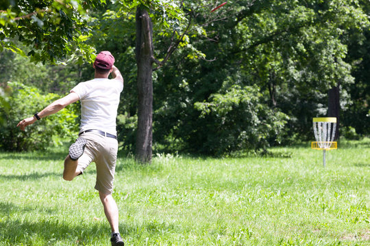 Man throwing frisbee playing disc golf