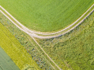 Aerial view of curved path in rural area. Trail through fields.